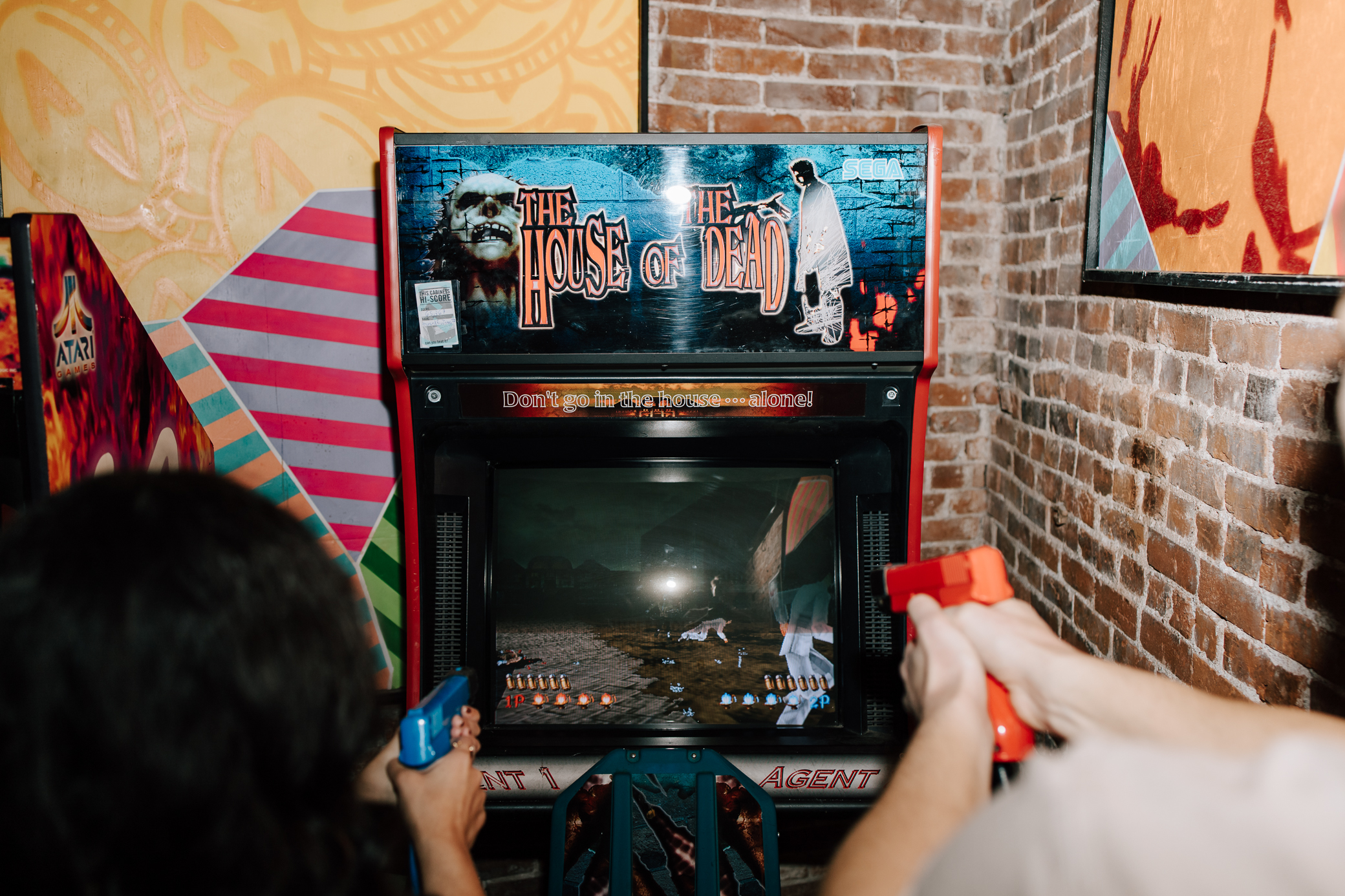 The House of the Dead arcade game being played by an engaged couple at Up-Down Arcade in St. Louis.