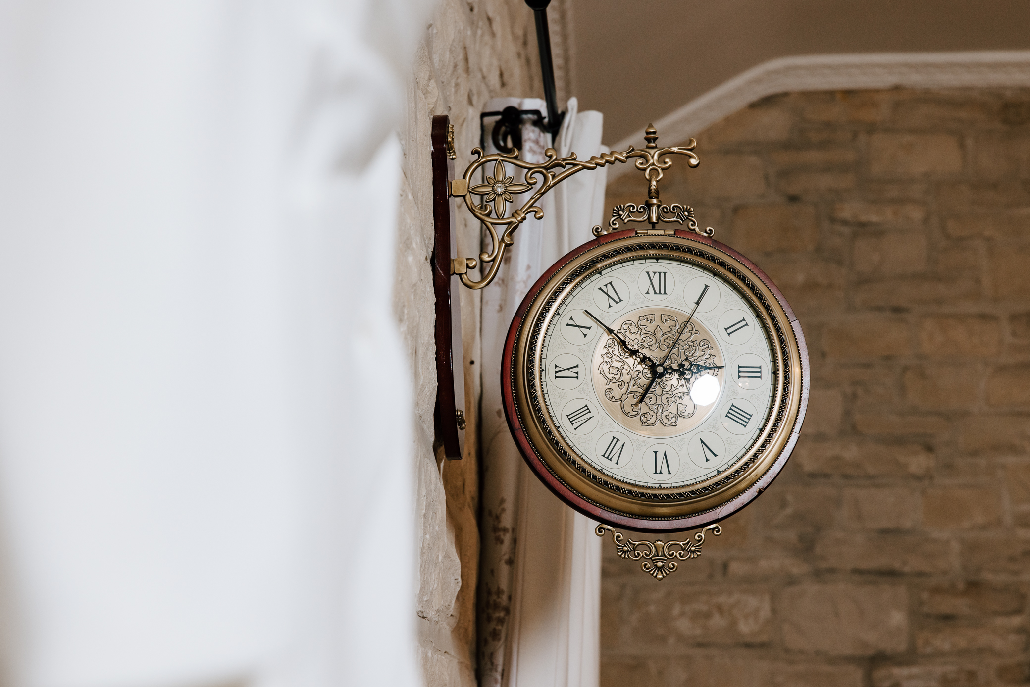 A gold antique clock mounted on the wall of the bridal suite at Knotting Hills in Pevely, Missouri shows the time 2:52 pm.